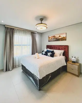 a bedroom with a large bed and a window at Goodness Century Apartment in Cape Town