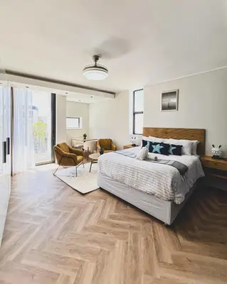 a bedroom with a large bed and a living room at Grace On Park by Dajosha in Cape Town