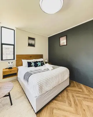 a bedroom with a large white bed and a black wall at Grace On Park by Dajosha in Cape Town
