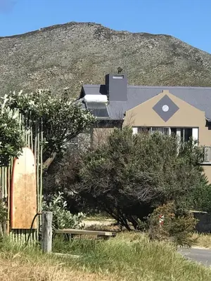 a house with a hill in the background at 120 steps to the beach in Pringle Bay