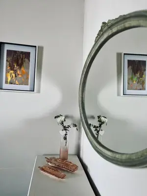 a table with a mirror and a vase with flowers at Hephzibah Inn Signature Farm Cottage in Hermon
