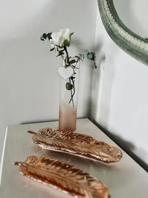 a table with a vase with a flower and a mirror at Hephzibah Inn Signature Farm Cottage in Hermon