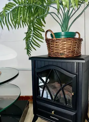 a basket on top of a black cabinet with a plant at Hephzibah Inn Signature Farm Cottage in Hermon
