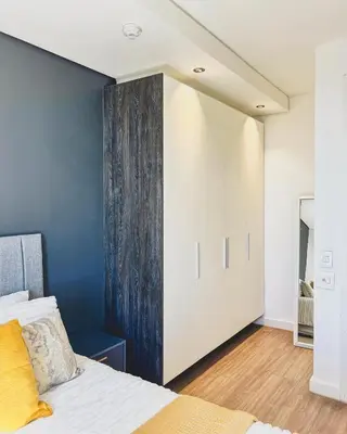 a bedroom with a bed and a blue wall at Shalom on Matrix by Dajosha in Cape Town