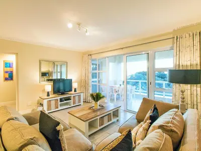 a living room with a couch and a tv at Goldwater 7 in Gordonʼs Bay