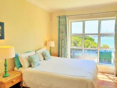 a bedroom with a bed with a large window at Goldwater 7 in Gordonʼs Bay