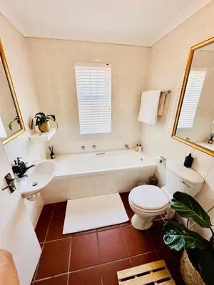 a bathroom with a tub and a toilet and a sink at Dolce in Cape Town
