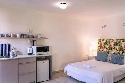a small room with a bed and a kitchen at Mountainside Beach House in Hermanus
