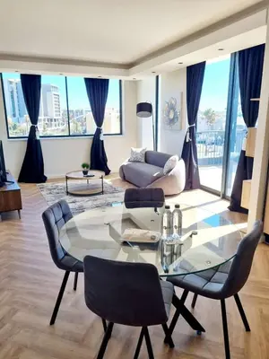 a living room with a glass table and chairs at On Park by Smart City Stays in Cape Town