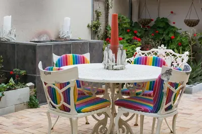 a white table with chairs and a candle on it at 9 Lantra in Strand