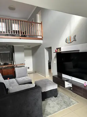 a living room with a couch and a flat screen tv at YA Eagle Wings Self Catering Shared Single room Lodge B in Cape Town