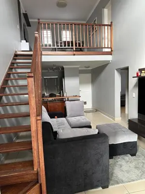 a living room with a couch and a staircase at YA Eagle Wings Self Catering Shared Single room Lodge B in Cape Town