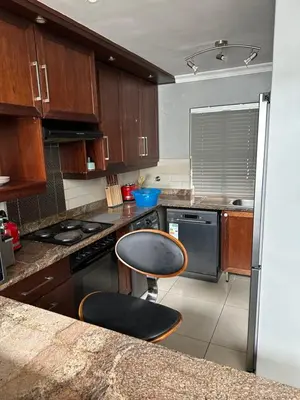 a kitchen with a counter and a chair in it at YA Eagle Wings Self Catering Shared Single Room Lodge A in Cape Town