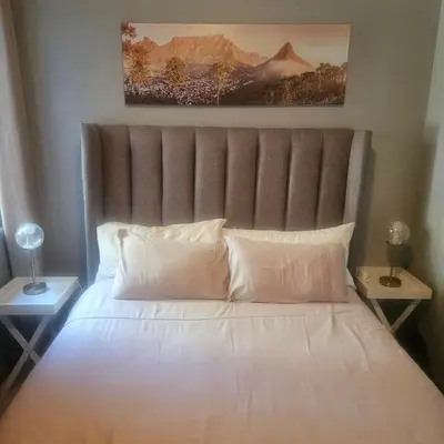 a large bed with white pillows in a bedroom at Mimi's in Plattekloof