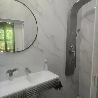 a white bathroom with a sink and a mirror at Mimi's in Plattekloof