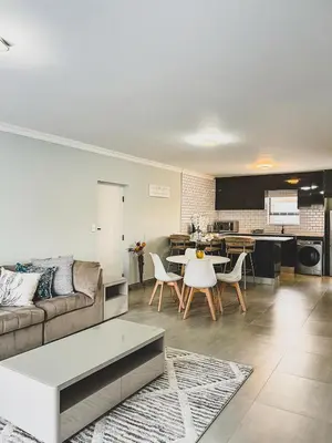 a living room with a couch and a table at Hope Century Apartments in Cape Town