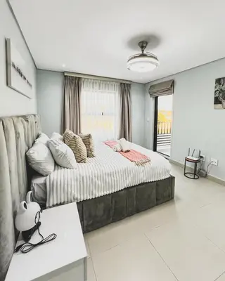 a bedroom with a large bed and a window at Hope Century Apartments in Cape Town