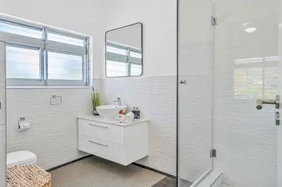 a white bathroom with a sink and a shower at Self-Catering Winelands Views Apartment Stellenbosch in Stellenbosch