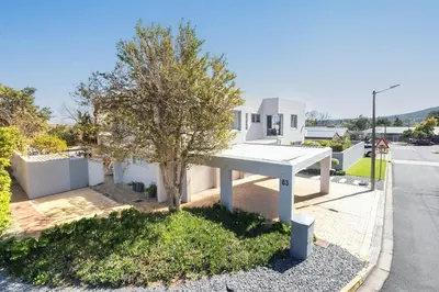 a white bench next to a tree on a street at Self-Catering Winelands Views Apartment Stellenbosch in Stellenbosch