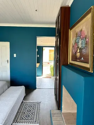 a blue room with a painting of flowers on the wall at Blue Cottage, Elgin Grabouw in Grabouw