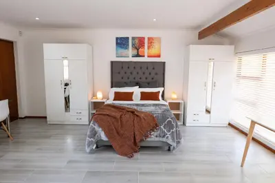 a bedroom with a bed and two windows at Mystical Serenity in Durbanville