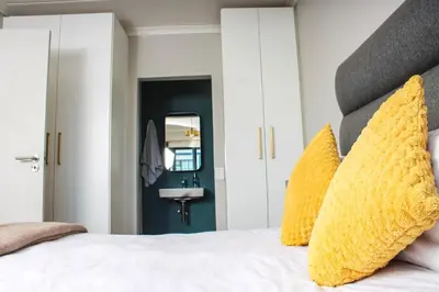 a bedroom with a large white bed with yellow pillows at Water front apartment-Ocean Palace in Tyger Valley