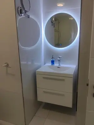 a white bathroom with a sink and a mirror at Water front apartment-Ocean Palace in Tyger Valley