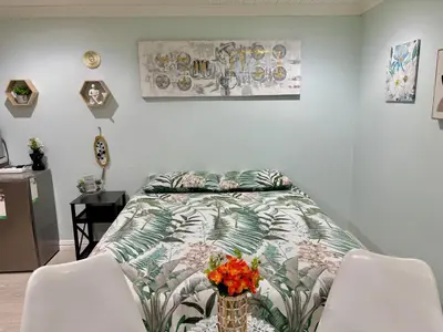 a bedroom with a bed with a flower vase on it at Bachelor Flat A in Goodwood