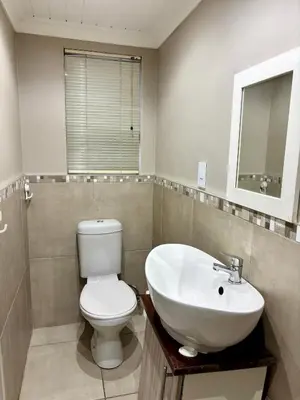 a bathroom with a white toilet and a sink at Bachelor Flat A in Goodwood