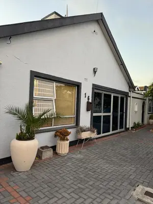 a white house with plants in front of it at Miches House in Cape Town