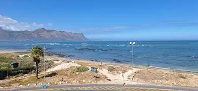 a beach with the ocean and mountains in the background at 210 at Beach in Strand