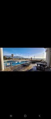 a picture of a beach with benches and a pool at 210 at Beach in Strand
