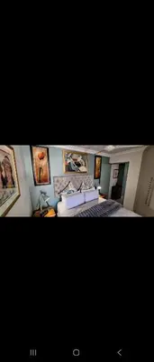 a bedroom with a bed and pictures on the wall at 210 at Beach in Strand