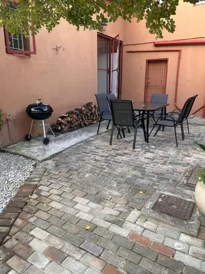 a patio with a table and chairs and a grill at Bergstreet in Hermanus