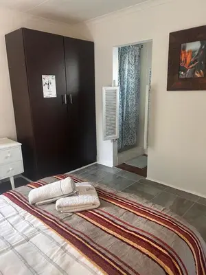 a bedroom with a bed with two pillows on it at Bergstreet in Hermanus