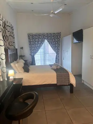 a bedroom with a large bed with a window at Bergstreet in Hermanus
