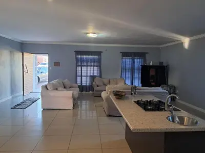 a kitchen and living room with a couch and a table at Spacious Home-Quiet area, Kuils river, Cape Town in Blackheath