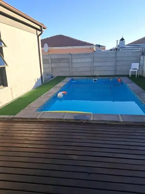 a swimming pool in the backyard of a house at Spacious Home-Quiet area, Kuils river, Cape Town in Blackheath