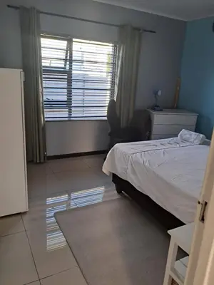 a bedroom with a bed and a large window at Spacious Home-Quiet area, Kuils river, Cape Town in Blackheath