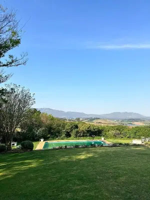 a swimming pool in a field with a green lawn at Green Cottage, Elgin Grabouw in Grabouw