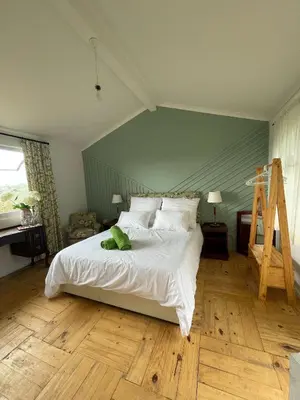 a bedroom with a white bed and a wooden floor at Green Cottage, Elgin Grabouw in Grabouw