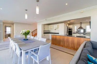 a dining room and kitchen with a table and chairs at Somer Sout in Voelklip, Hermanus in Hermanus