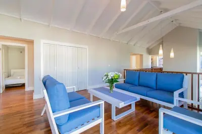 a living room with a blue couch and a table at Somer Sout in Voelklip, Hermanus in Hermanus