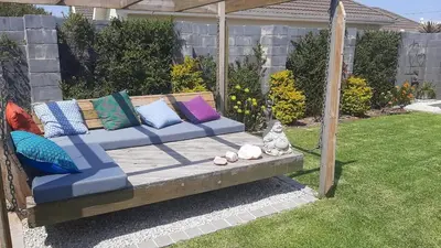 a blue couch with colorful pillows on it in a yard at Flow in Hermanus