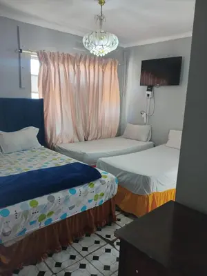 a room with two beds and a chandelier at BDC Paarl Accommodation and Guest House in Paarl