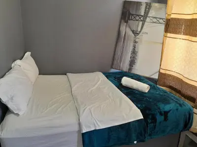 a bed in a small room with a window at BDC Paarl Accommodation and Guest House in Paarl