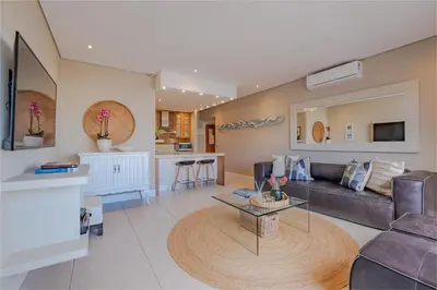 a living room with a couch and a table at Hermanus Marine Square spacious 1 bedroom- central & close to sea in Hermanus