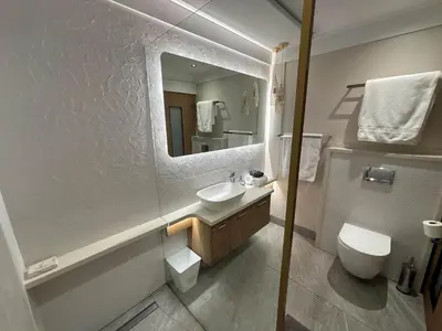 a bathroom with a sink and a toilet and a mirror at Bayview 107 in Hermanus