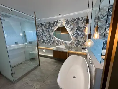 a bathroom with a toilet and a sink and a mirror at Bayview 107 in Hermanus