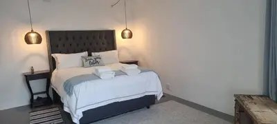 a bedroom with a bed with two towels on it at Coral Vistas Self Catering Apartments in Gordonʼs Bay